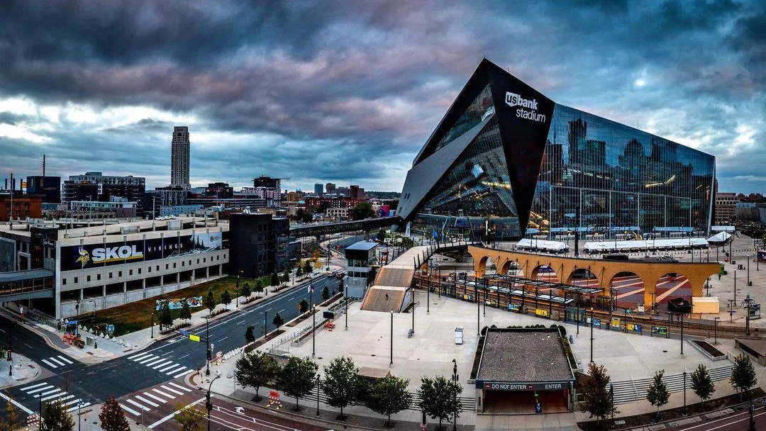 Stadium and surrounding streets beneath a dramatic sky